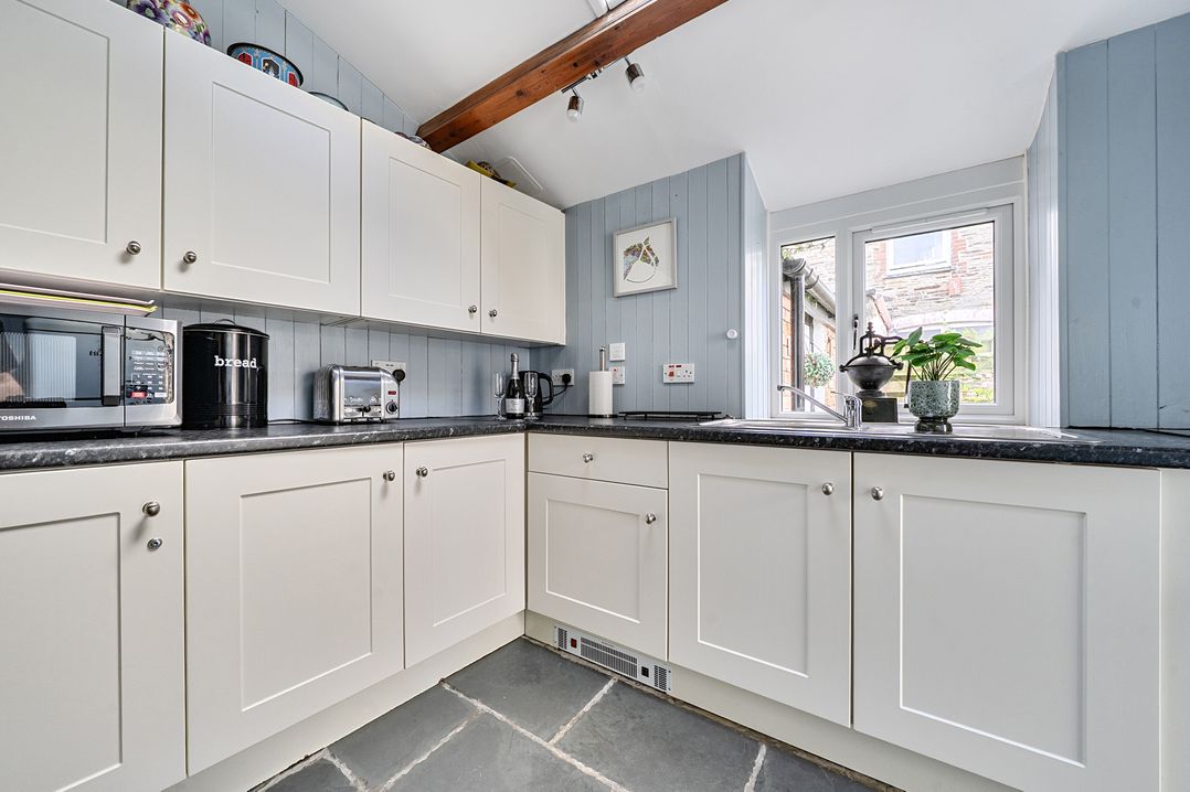 A kitchen with cabinets and appliances at Mews Cottage in Tintagel