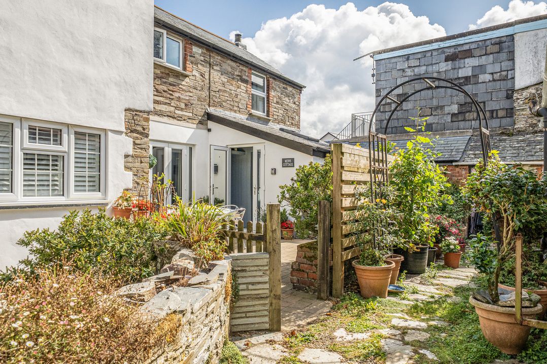 A garden with plants and a gate at Mews Cottage Tintagel