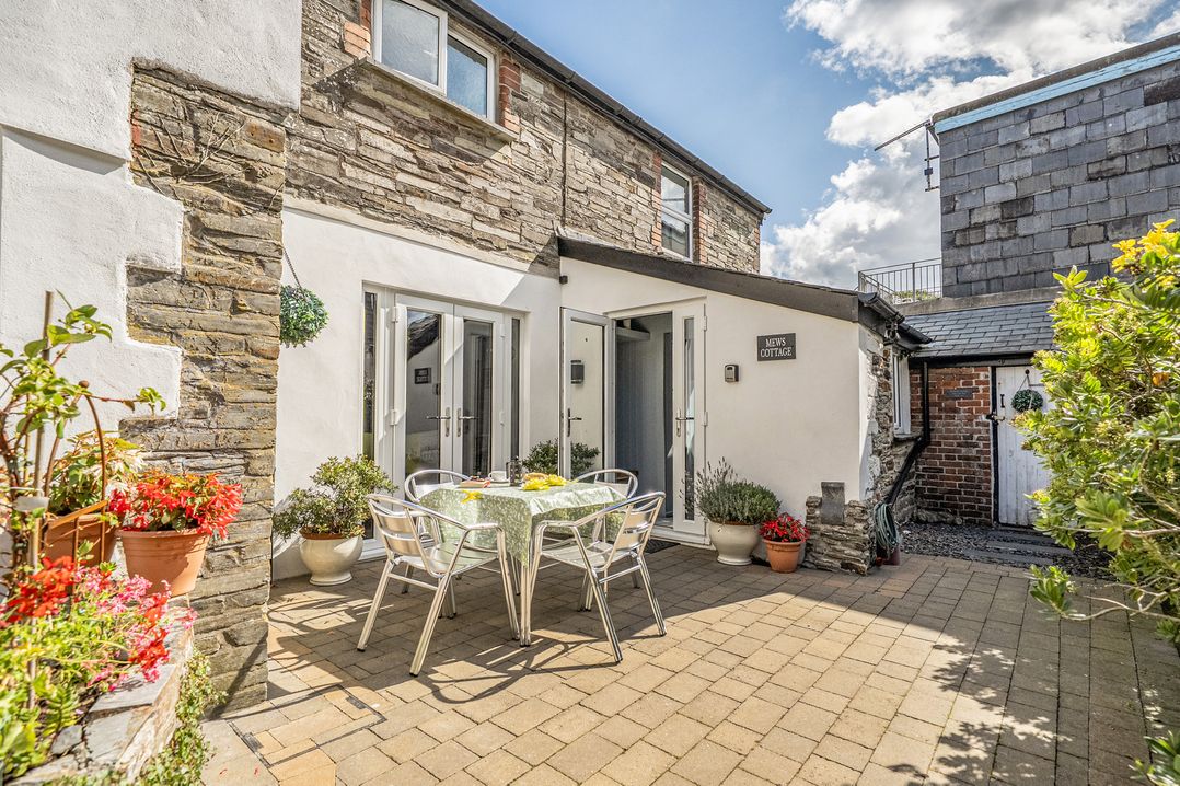 An outdoor dining area with a table and chairs at Mews Cottage Tintagel