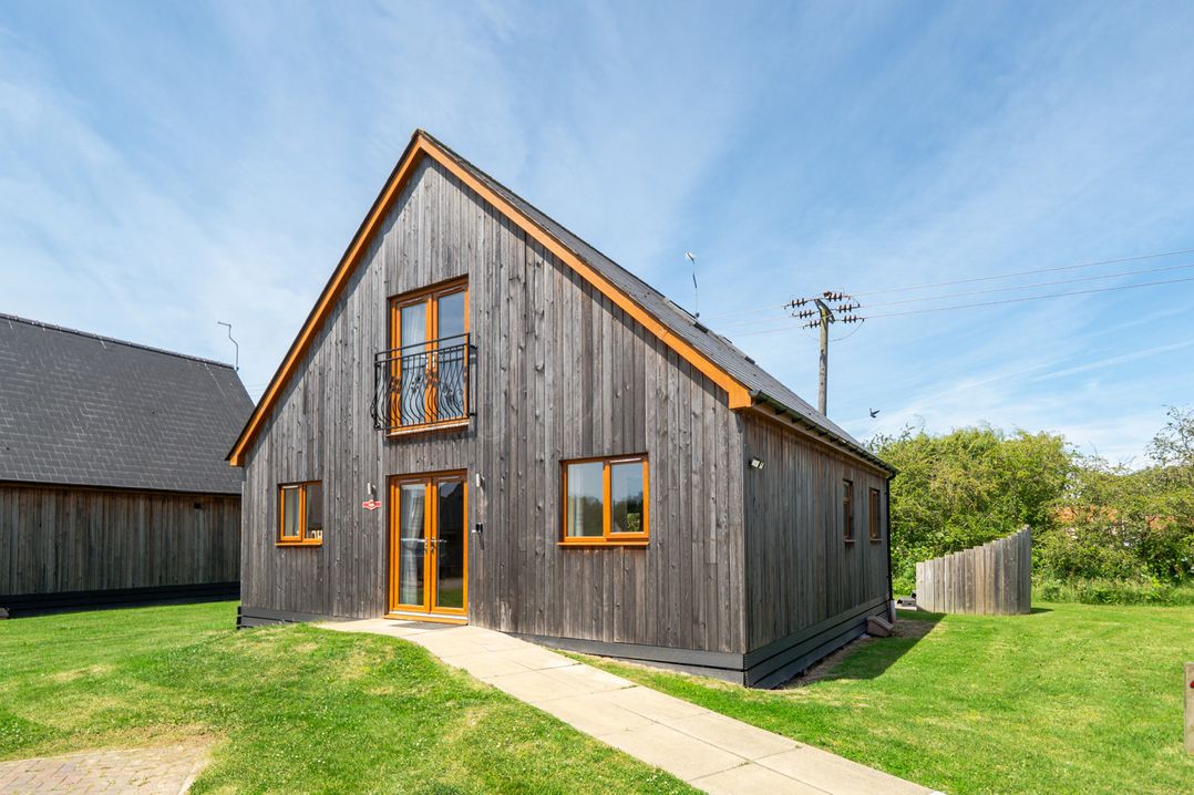 A house with wooden exterior and balcony at Aspen Lodge Near Brigg