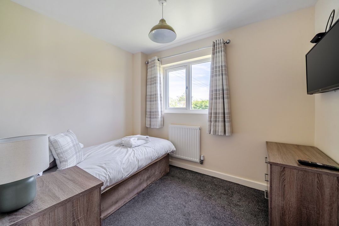 A bedroom with a single bed and a television at Aspen Lodge Near Brigg