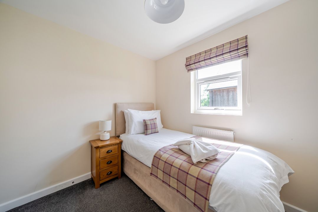 A bedroom with a single bed and bedside table at Paddington Lodge Near Brigg