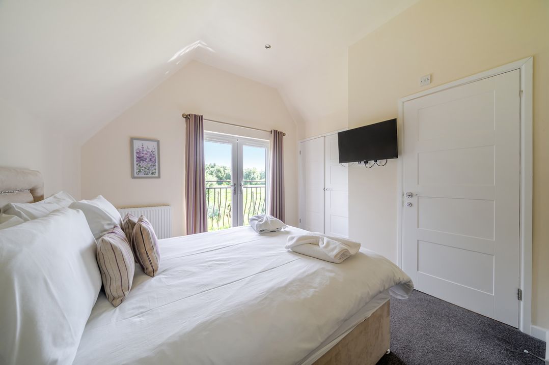 A bedroom with a bed and television at Paddington Lodge near Brigg