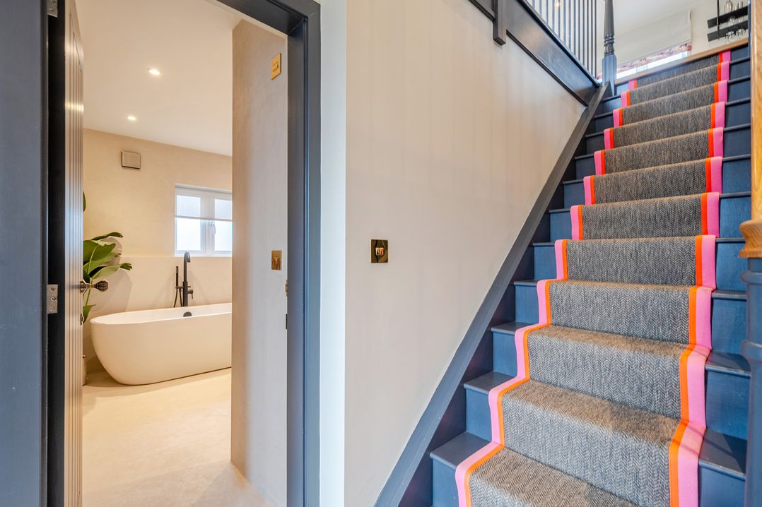 A hallway with a staircase and a bathtub visible at Bell House in Llanfechell