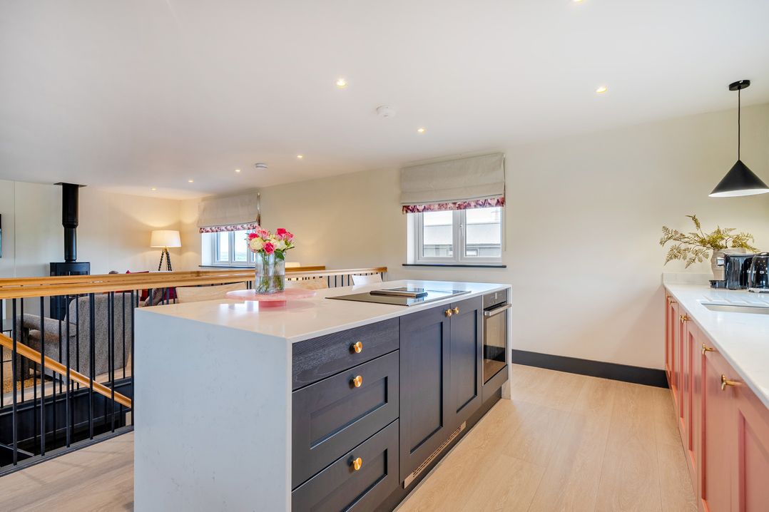 A kitchen with an island and cabinets at Bell House in Llanfechell