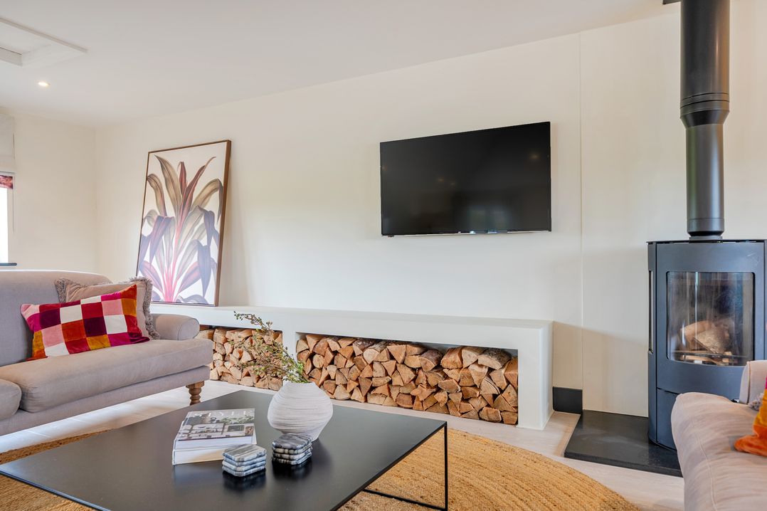 A living room with a television and a fireplace at Bell House in Llanfechell