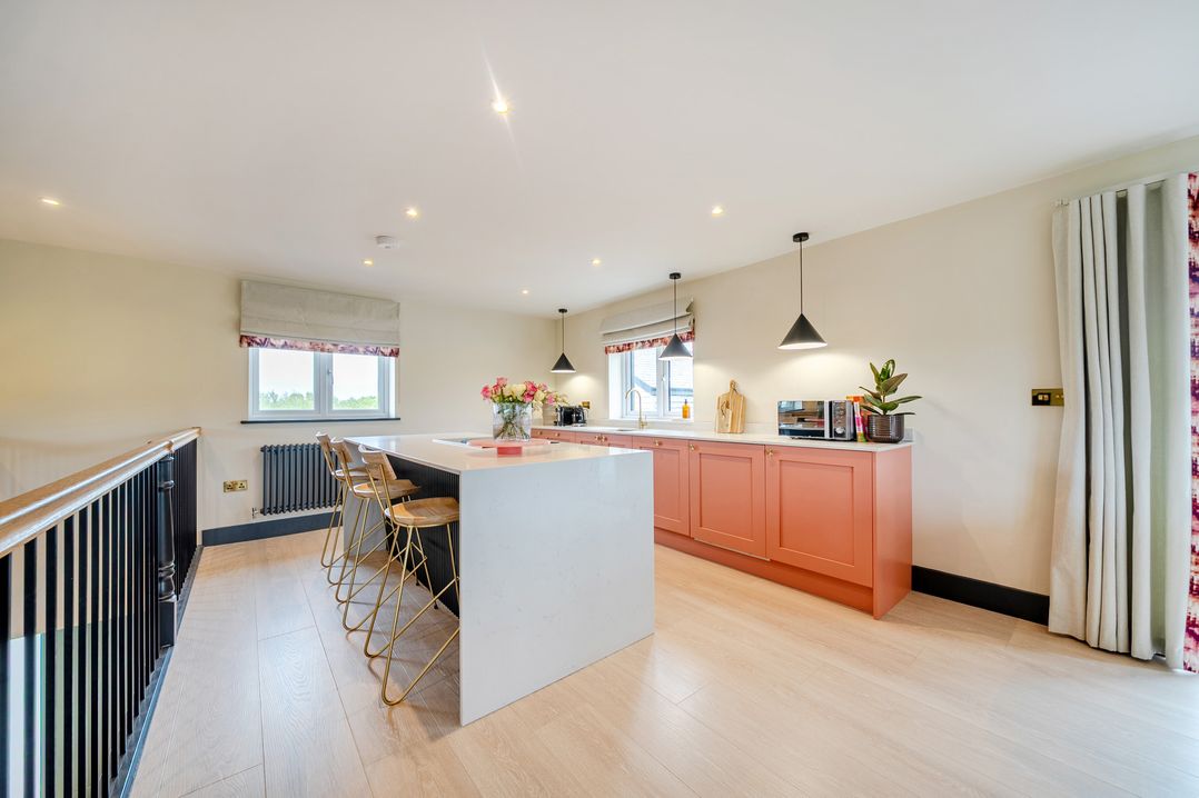 A kitchen with an island and stools at Bell House in Llanfechell