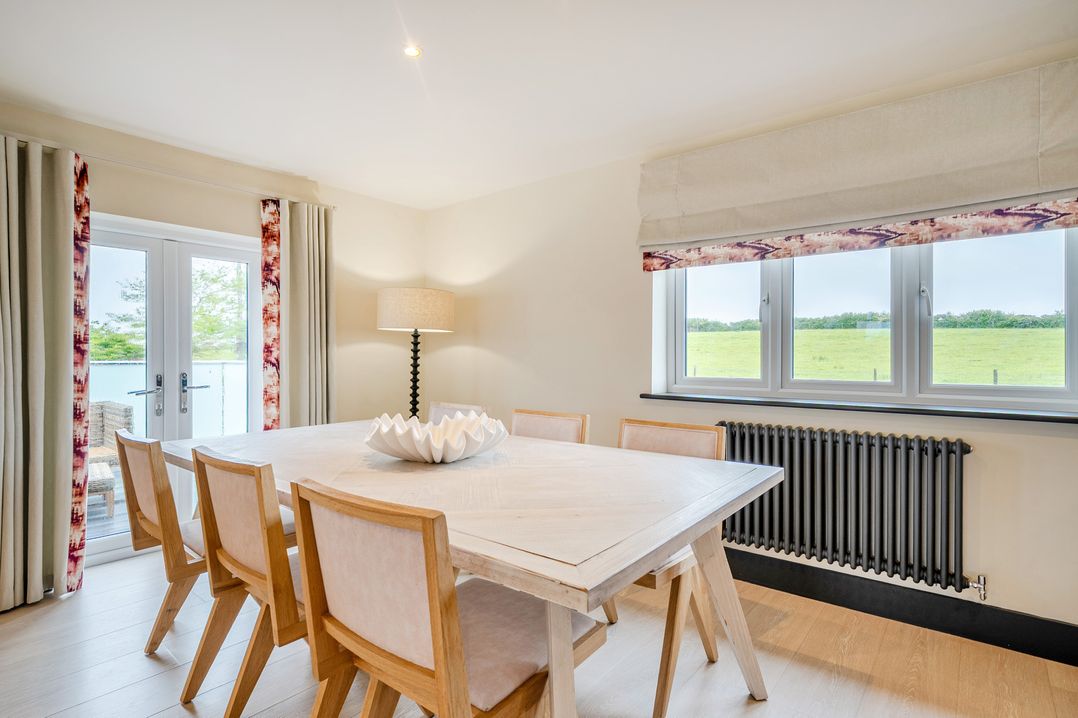 A dining room with a table and chairs at Bell House in Llanfechell