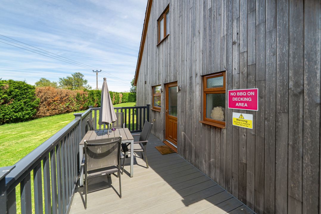 An outdoor decking area with table and chairs at James Ville Marina Lodge 8 in Brigg