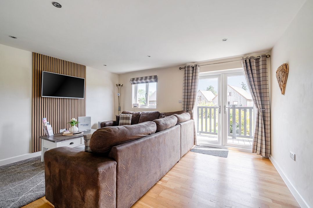 A living room with a sofa and television at James Ville Marina Lodge 8 in Brigg