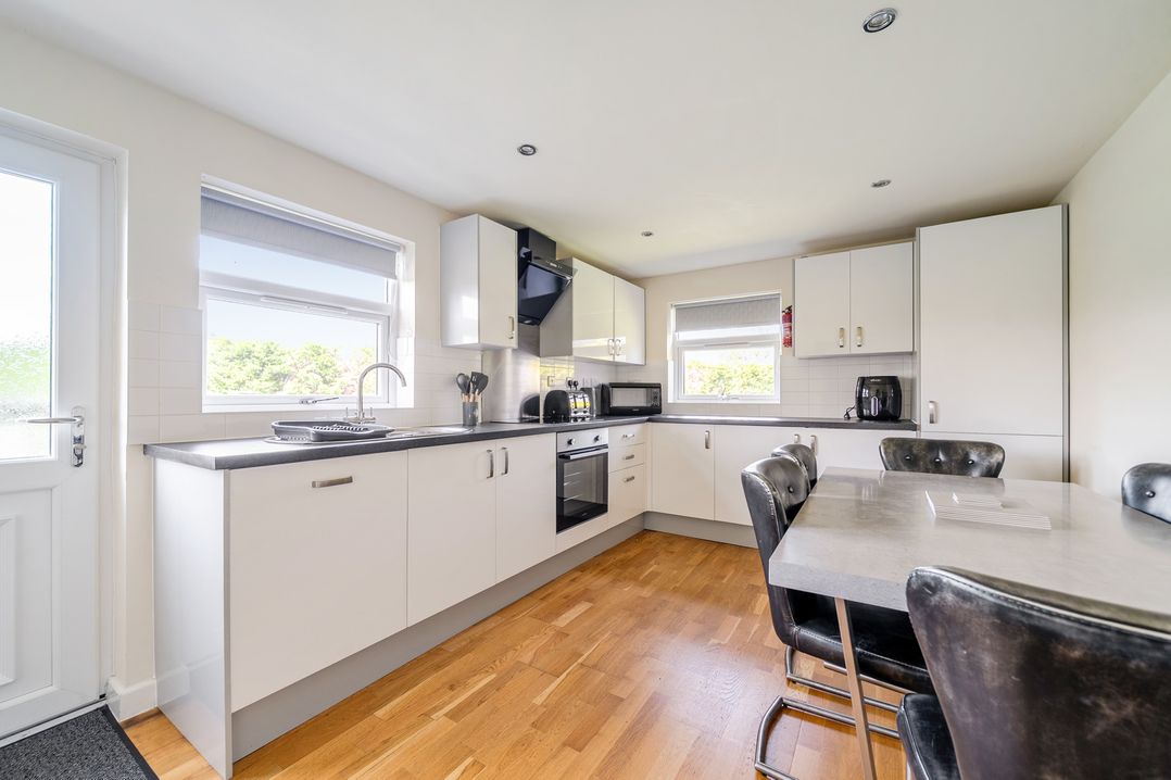 A kitchen with appliances and a dining table at James Ville Marina Lodge 8 in Brigg