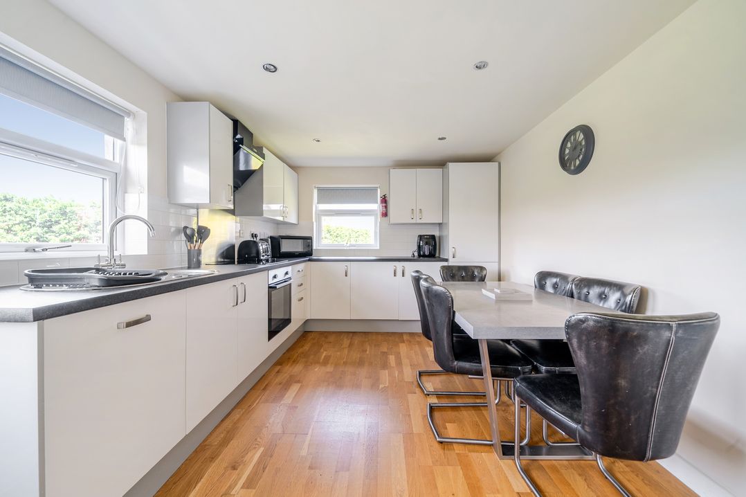 A kitchen with cabinets, appliances, and dining table at James Ville Marina Lodge 8, Brigg
