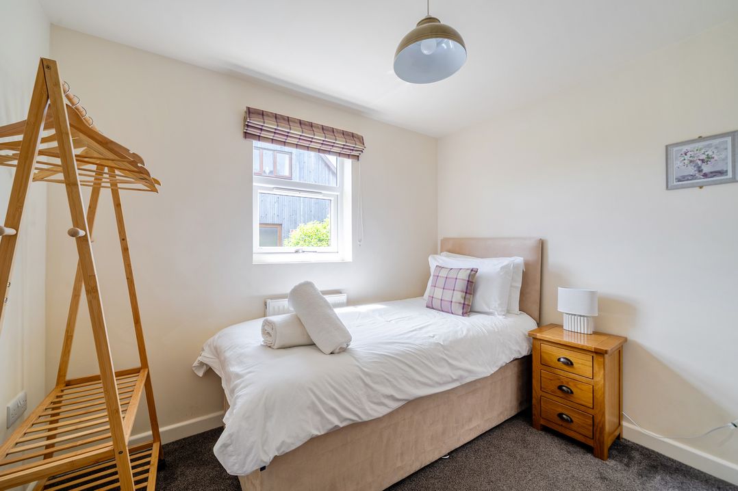 A bedroom with a single bed and clothes rack at James Ville Marina Lodge 8 in Brigg