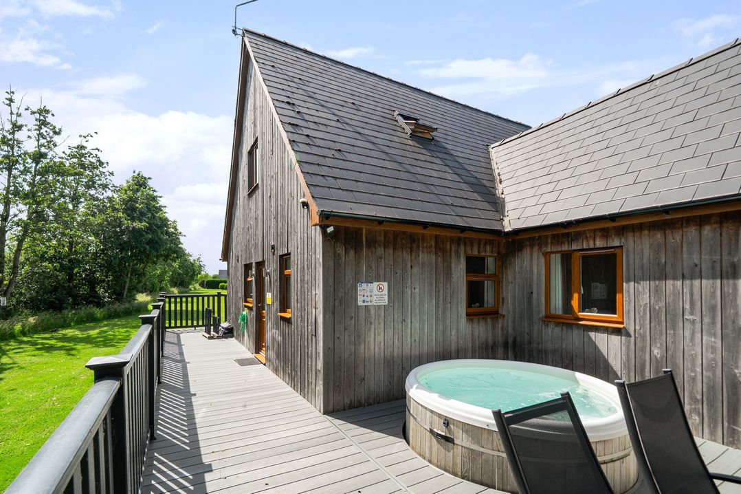 An outdoor area with a hot tub and wooden decking at James Ville Marina Lodge 13 in Brigg