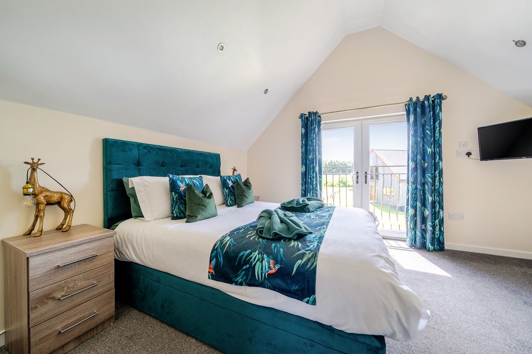 A bedroom with a bed and sliding doors at James Ville Marina Lodge 22 in Brigg