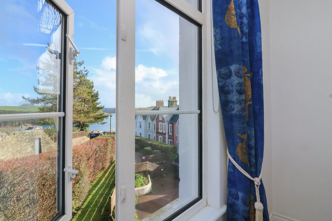 A window with a view of houses and trees at 4 The Elms Salcombe