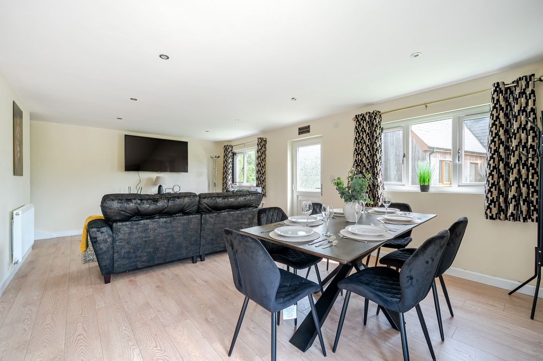 A living room with a sofa and dining table at Poker Lodge Near Brigg