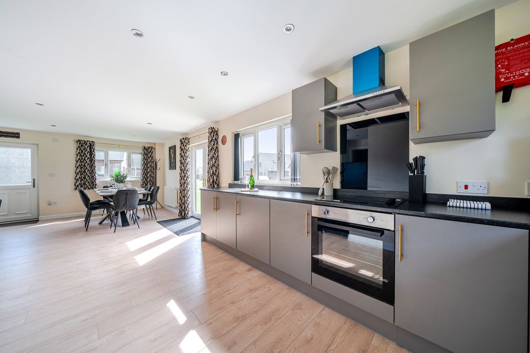 A kitchen with cabinets and a dining area at Poker Lodge Near Brigg