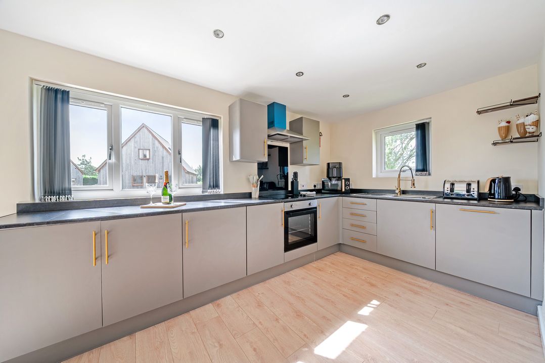 A kitchen with various appliances and windows at Poker Lodge Near Brigg