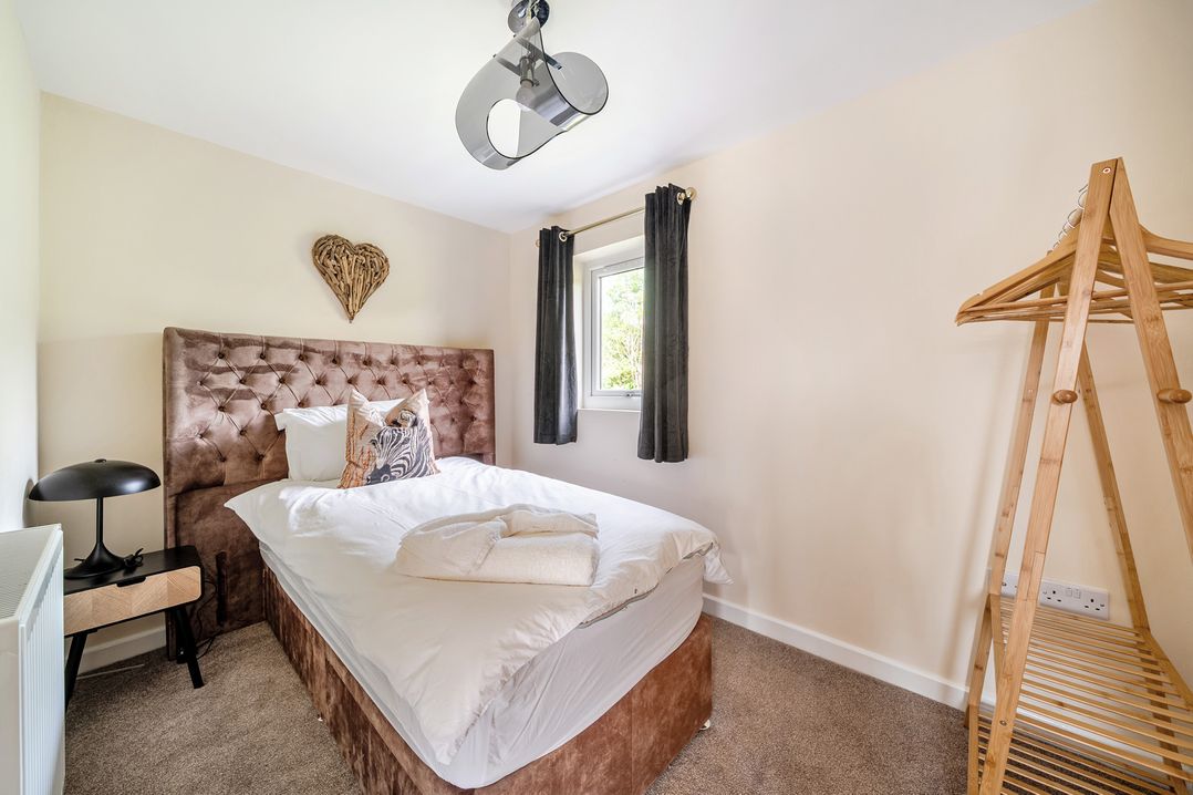 A bedroom with a bed and bedside lamp at Poker Lodge Near Brigg