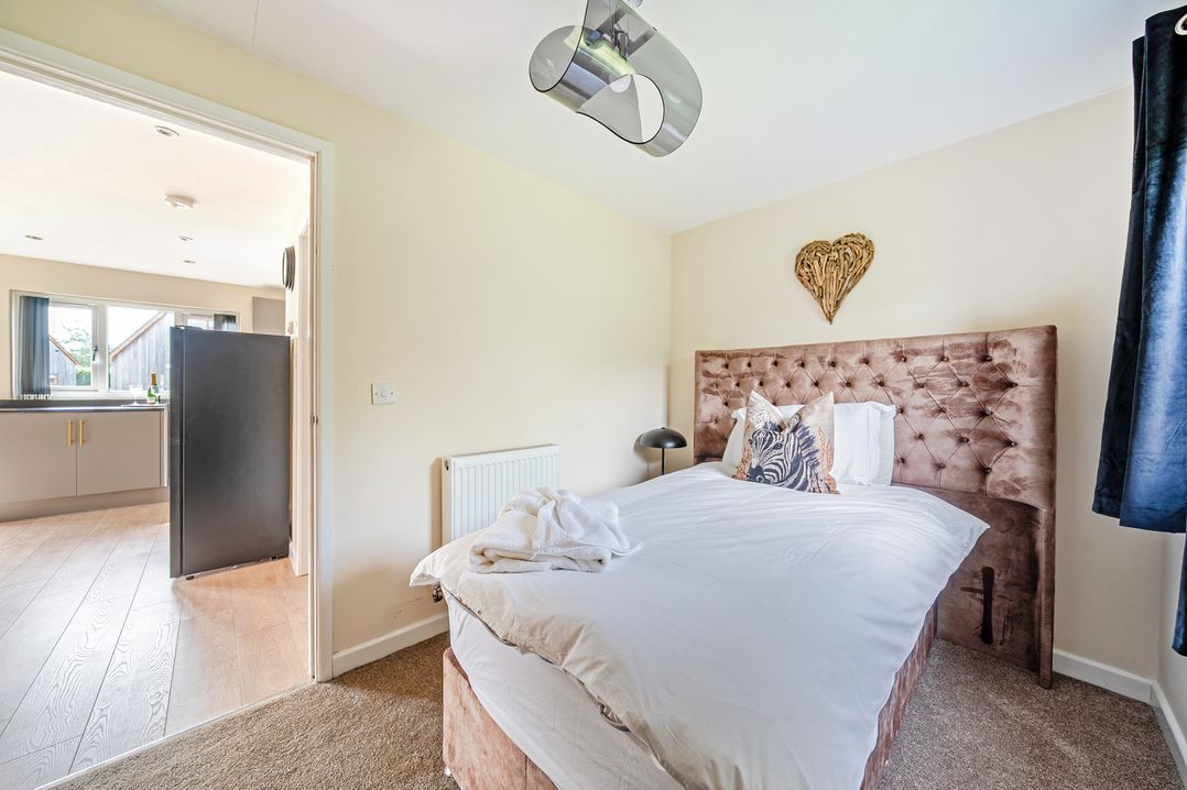 A bedroom with a bed and a doorway leading to another room at Poker Lodge Near Brigg