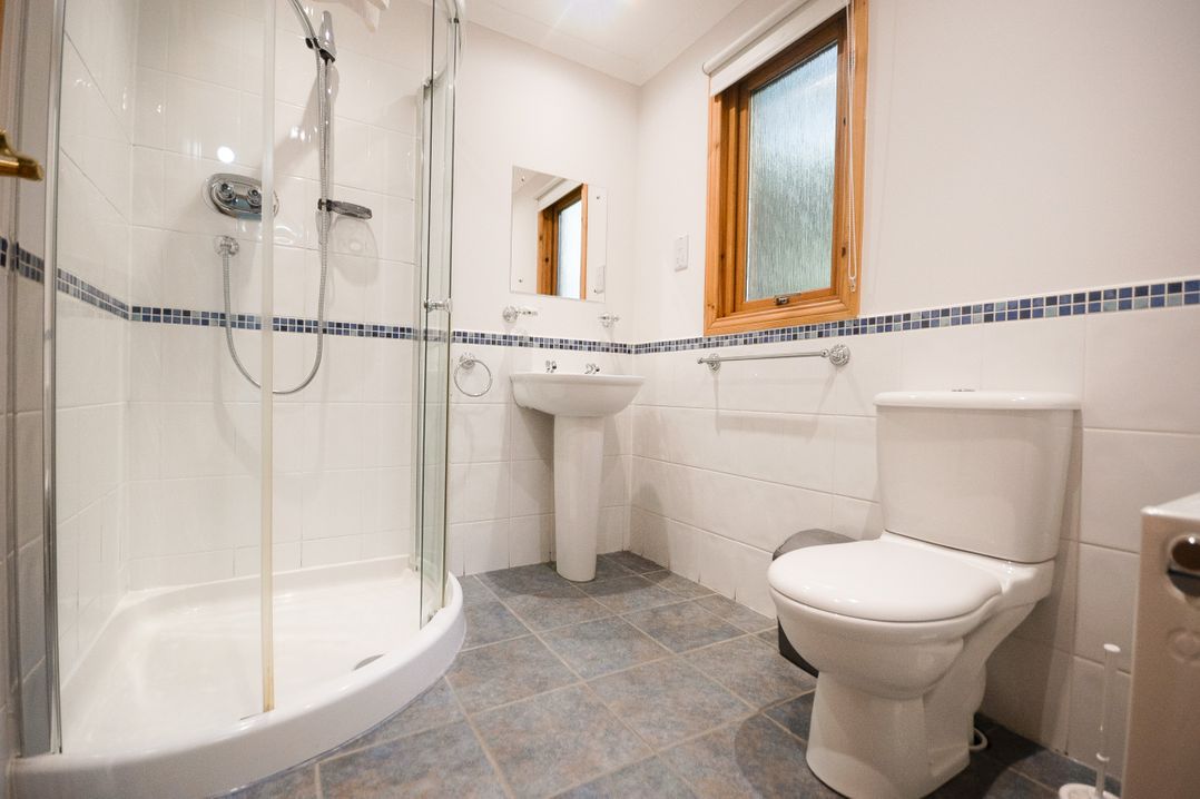 A bathroom with a shower, toilet, and sink at Sidlaw Spa, Fowlis near Dundee