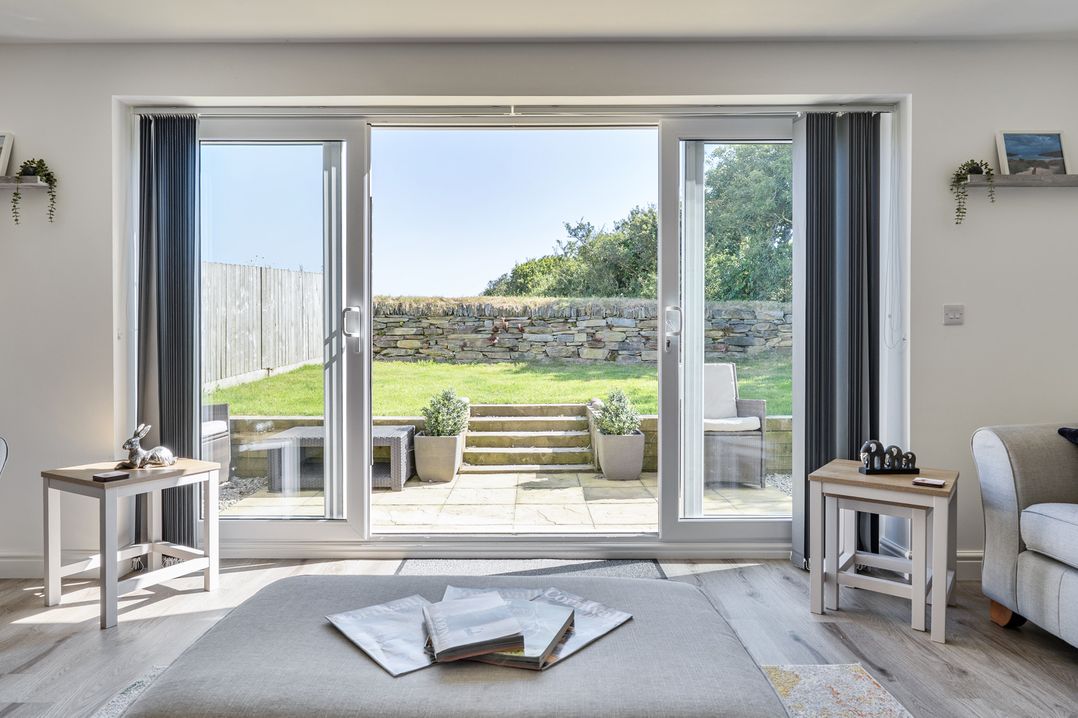 A living room with a view of the garden at Buttercup Cottage in St Merryn