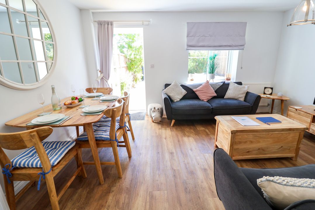 A living room with a dining area and a sofa at Lapwings, Aldeburgh