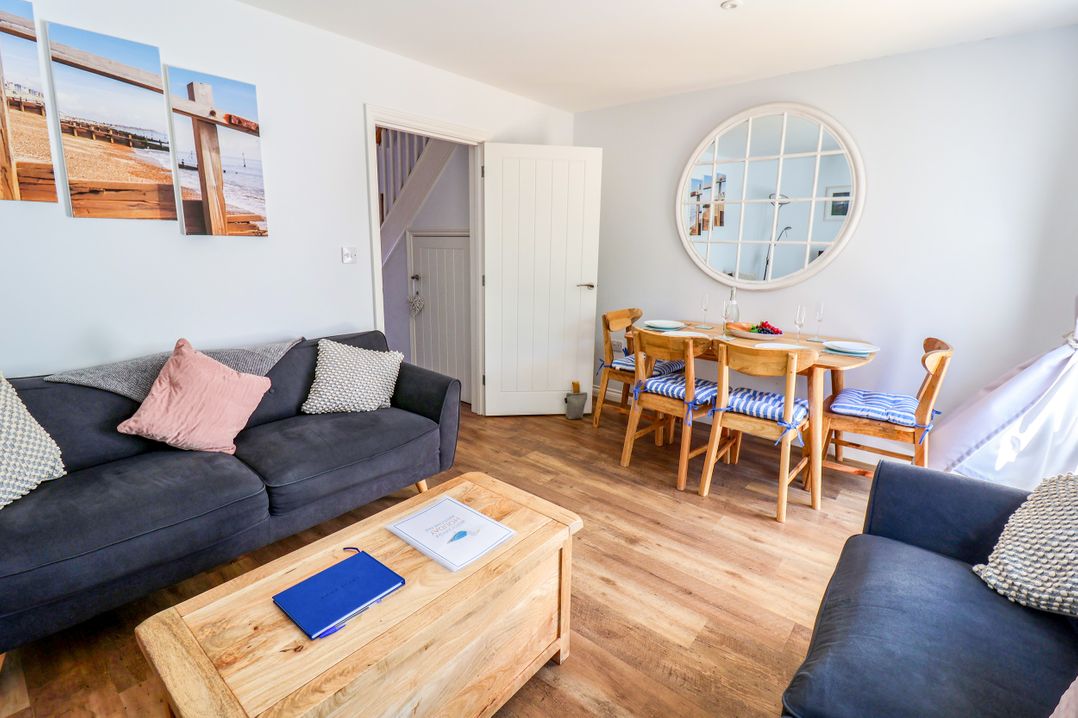 A living room with a sofa and dining area at Lapwings, Aldeburgh