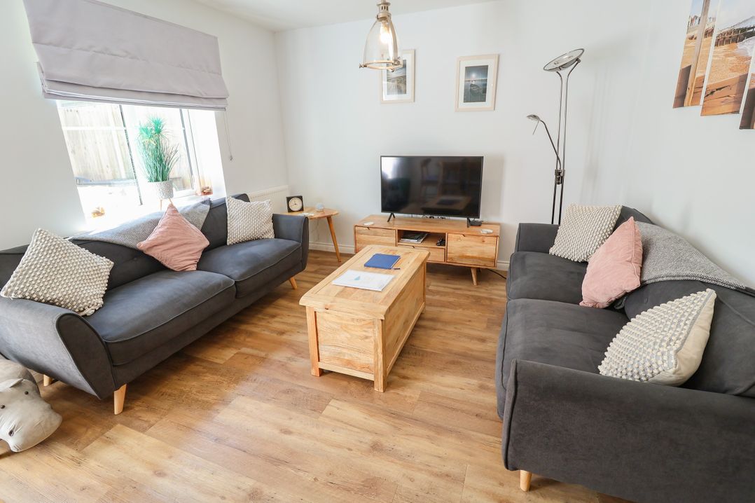 A living room with sofas and a television at Lapwings, Aldeburgh