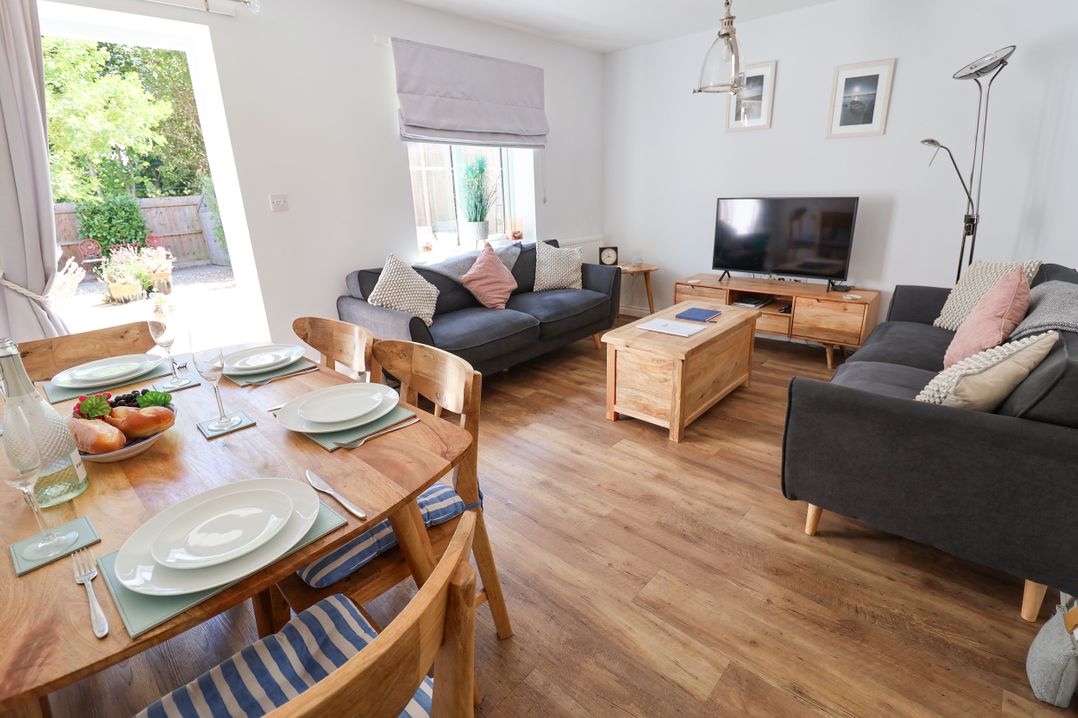 A living room with a dining table and sofas at Lapwings, Aldeburgh