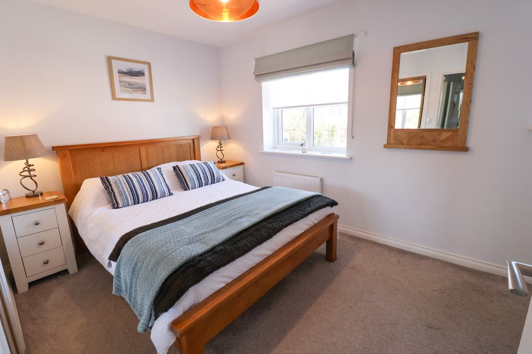 A bedroom with a double bed and bedside tables at Lapwings, Aldeburgh