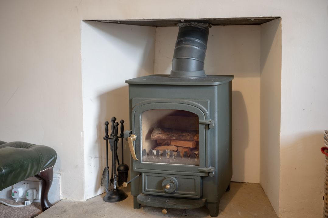 A wood stove with logs inside at Edengrove Aberfeldy