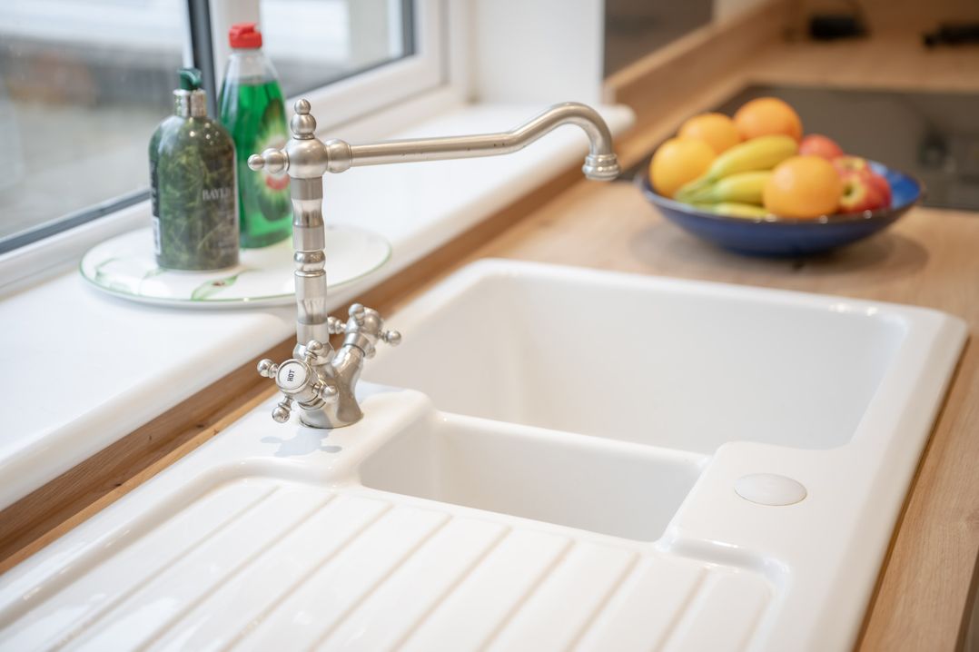 A kitchen with a tap and sink near a bowl of fruit at Edengrove in Aberfeldy