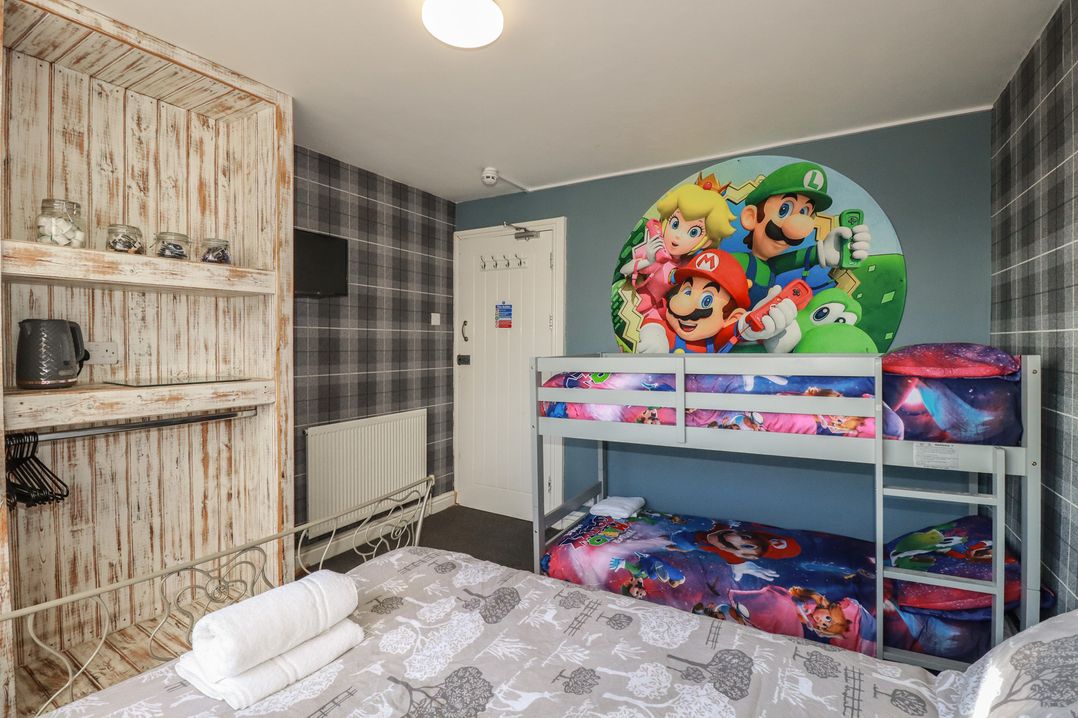 A bedroom with a bunk bed and wall art at Shoreline Apartment No.8 Newquay