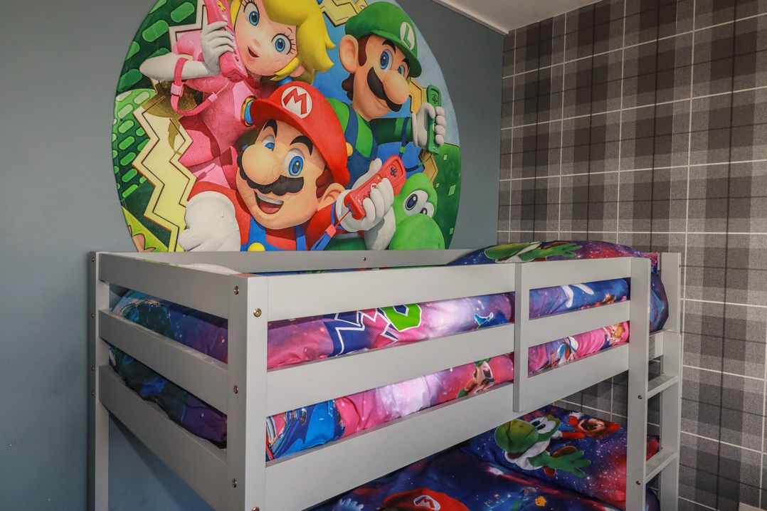 A bunk bed with themed bed sheets and a mural on the wall at Shoreline Apartment No.8 in Newquay