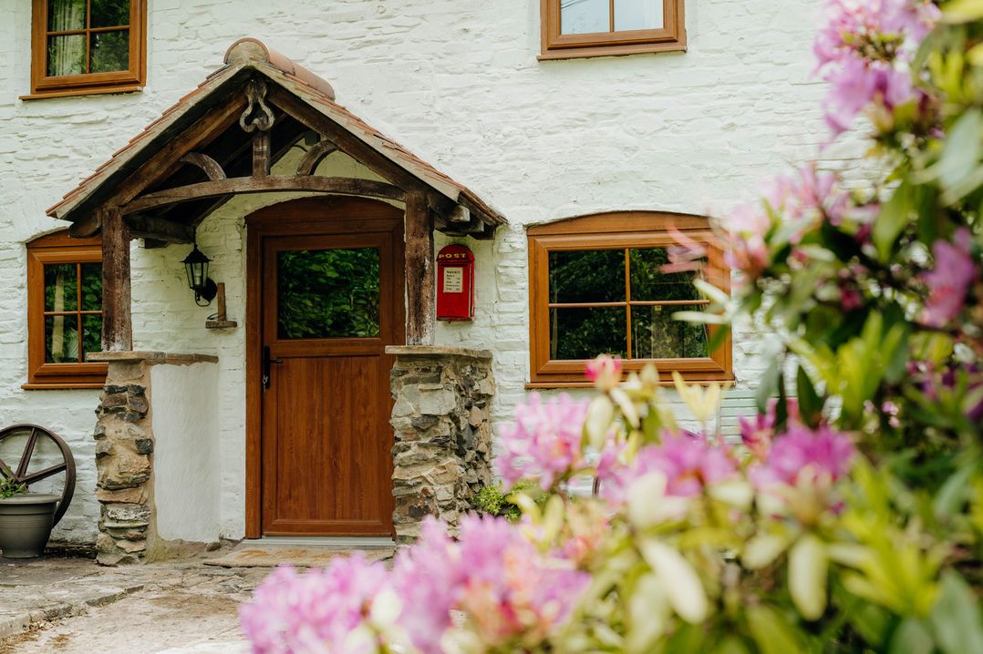 An entrance with a wooden door and flowers at The Wilderness in Stiperstones