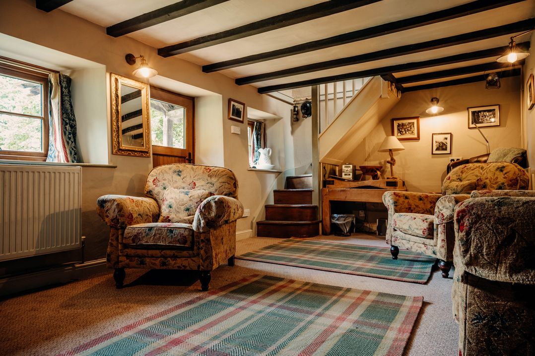 A living room with armchairs and a staircase at The Wilderness in Stiperstones