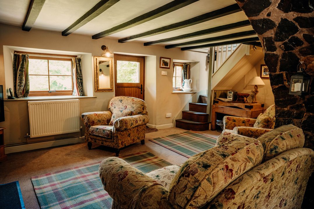 A living room with a sofa and armchair at The Wilderness Stiperstones