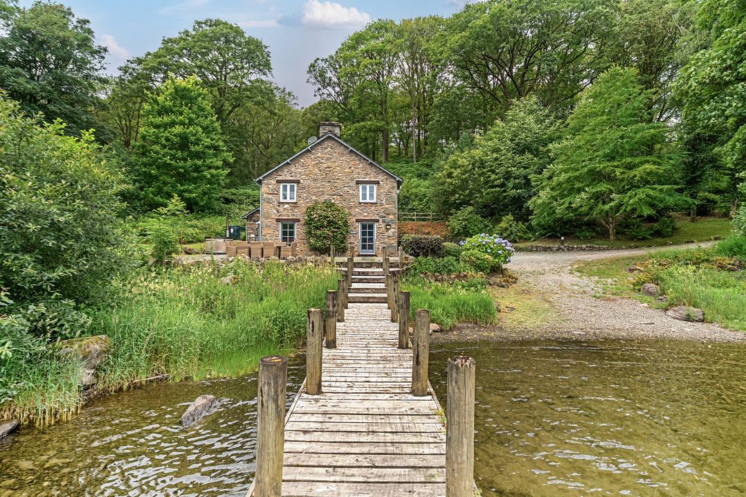A house by a dock with trees at Hammerhole at the Graythwaite Estate near Hawkshead