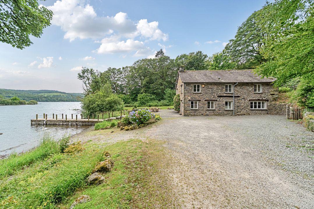 A house by a lake with a dock at Hammerhole at the Graythwaite Estate near Hawkshead