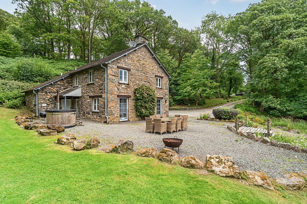 An outdoor area with a house, table and chairs at Hammerhole at the Graythwaite Estate near Hawkshead