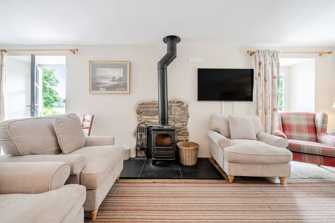 A living room with a fireplace and seating area at Hammerhole at the Graythwaite Estate near Hawkshead