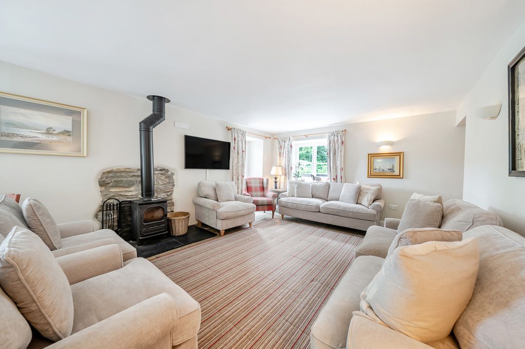 A living room with sofas and a fireplace at Hammerhole at the Graythwaite Estate near Hawkshead