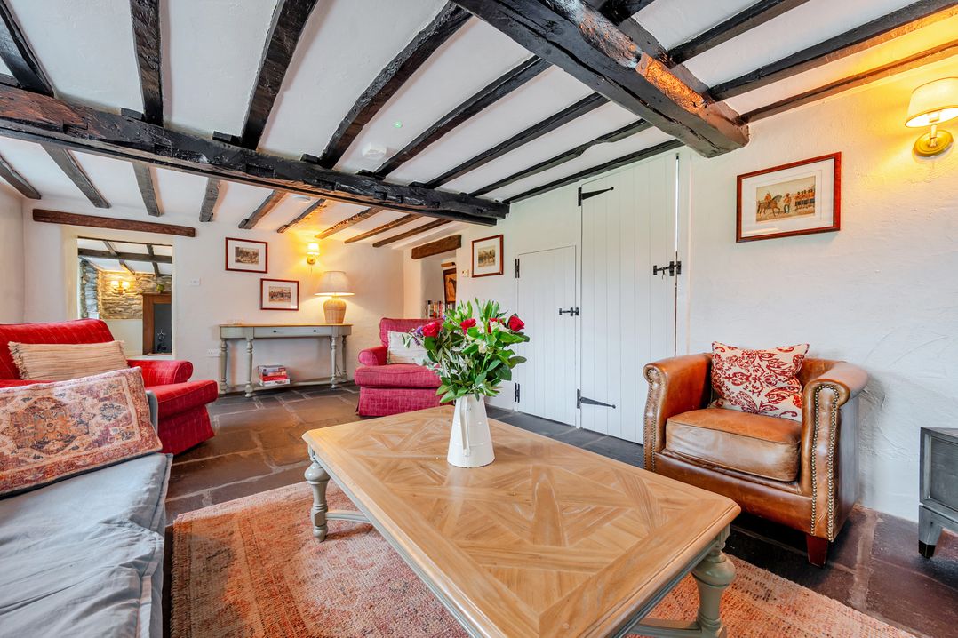 A living room with a sofa, armchair, and coffee table at Hullet Hall at the Graythwaite Estate near Hawkshead