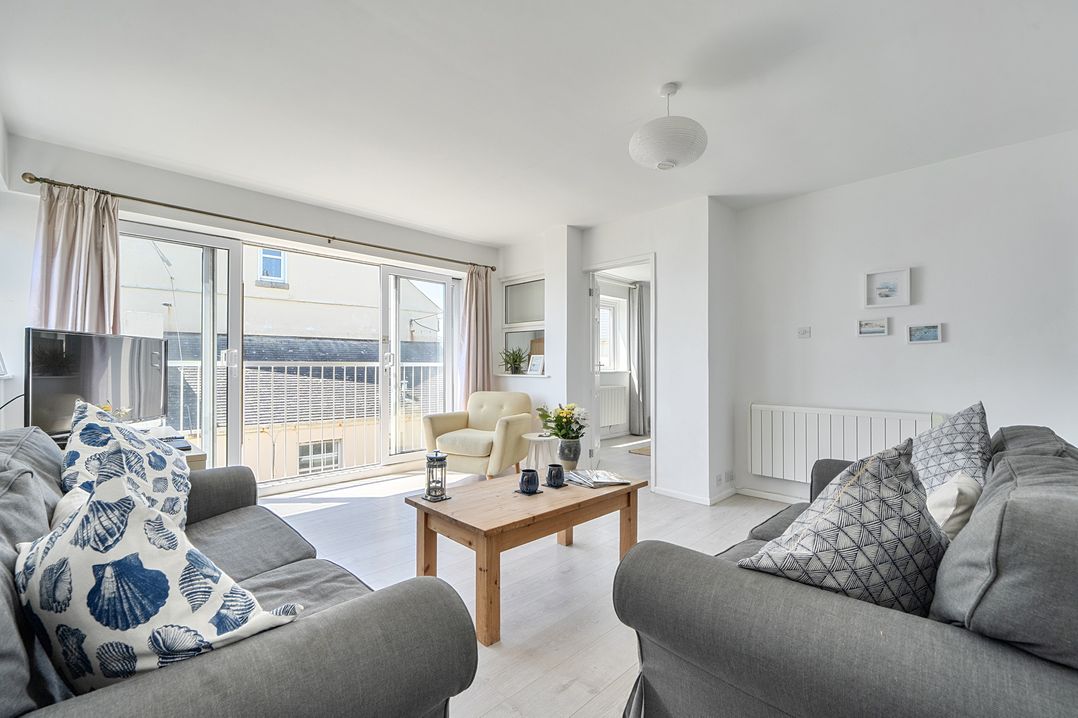 A living room with a sofa and chair at Brook House in Sennen Cove near St Just