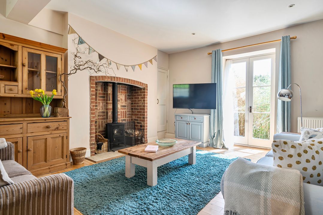 A living room with a wood stove and a television at East Wing in Crewkerne