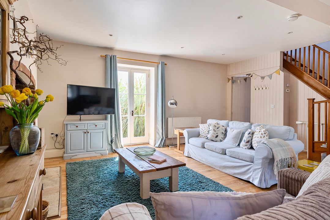 A living room with a sofa and television at East Wing in Crewkerne