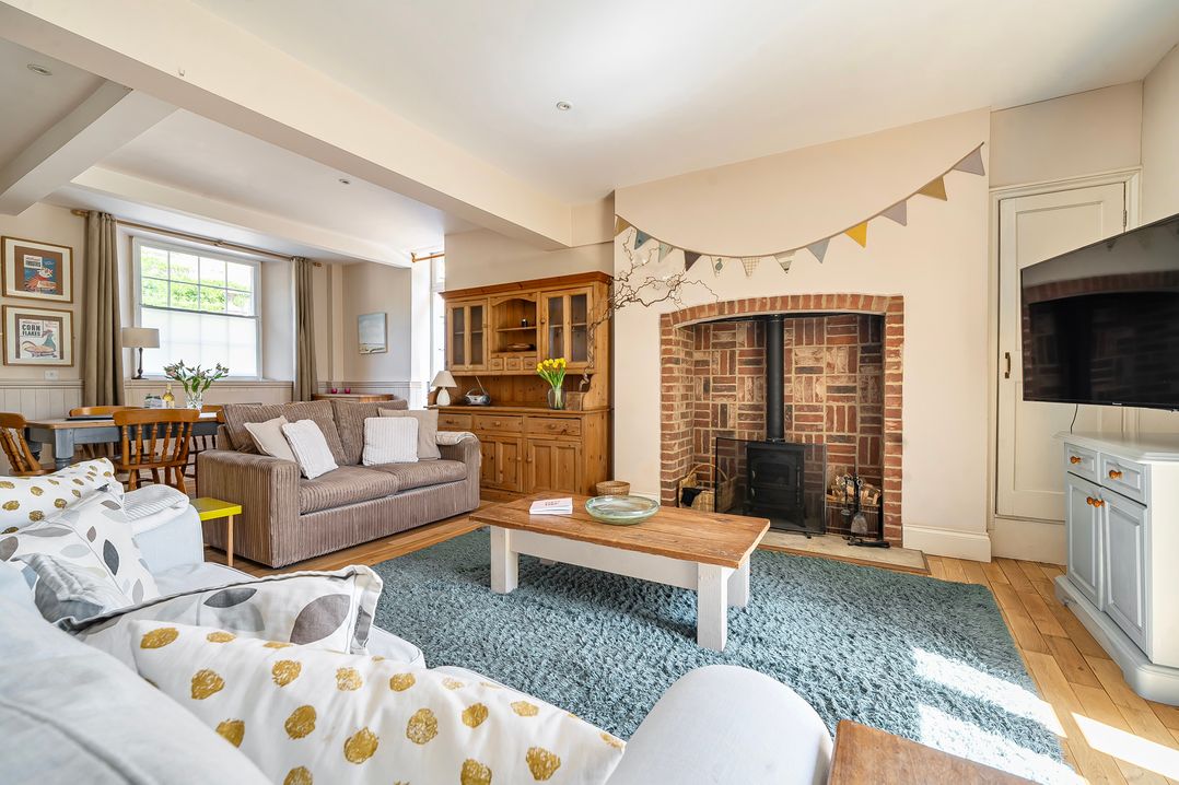 A living room with a fireplace and seating at East Wing in Crewkerne