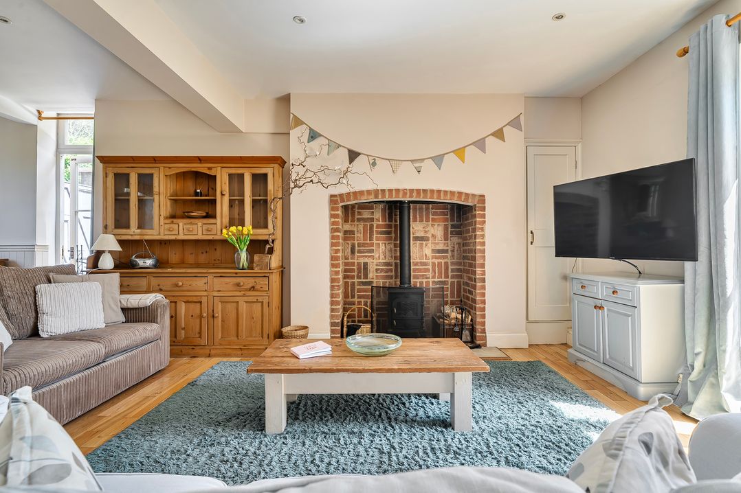 A living room with a fireplace and television at East Wing in Crewkerne